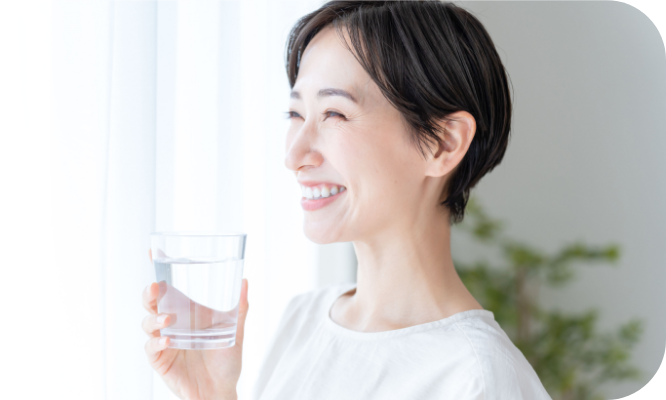 笑顔で水を飲む女性の写真